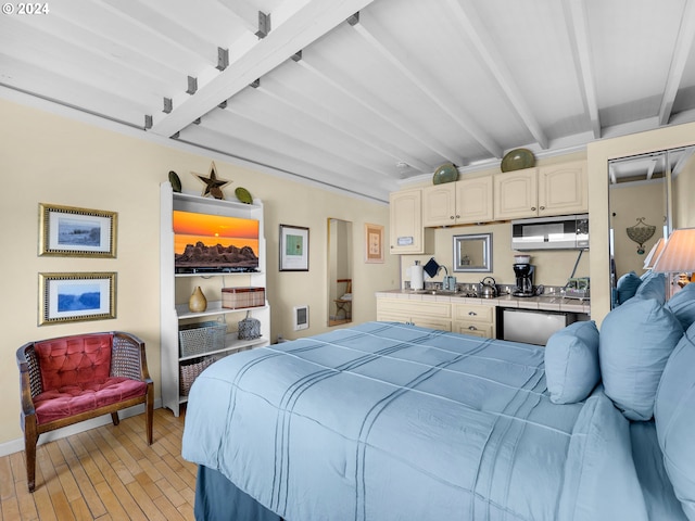 bedroom with light wood-type flooring, sink, and beamed ceiling