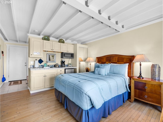 bedroom featuring beamed ceiling and light hardwood / wood-style floors