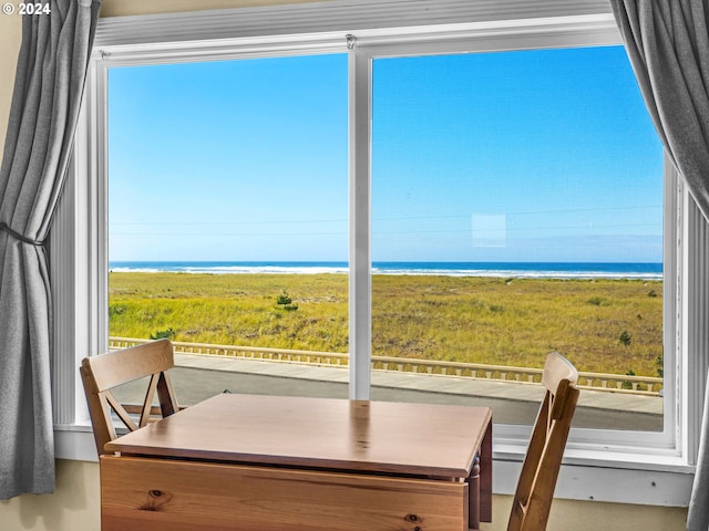 dining area with a view of the beach, a wealth of natural light, and a water view