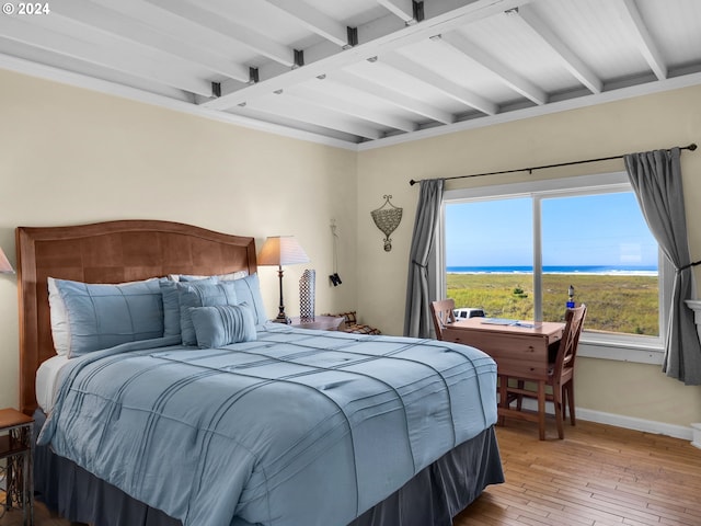 bedroom featuring light wood-type flooring and beam ceiling