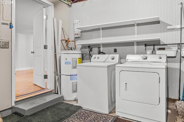 clothes washing area featuring electric water heater and washing machine and dryer