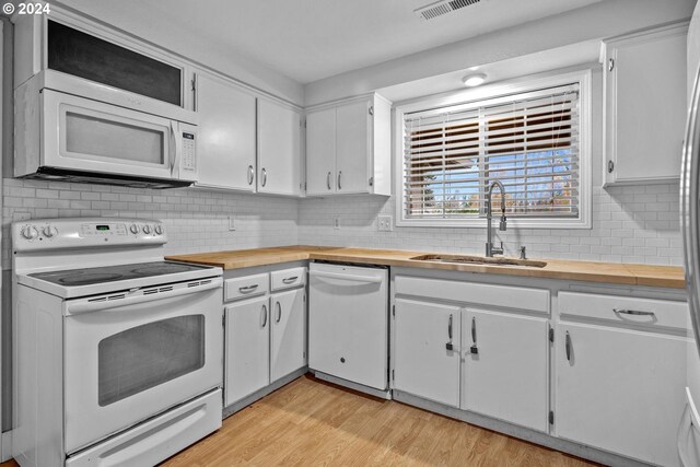 kitchen featuring white cabinets, white appliances, light hardwood / wood-style floors, and sink