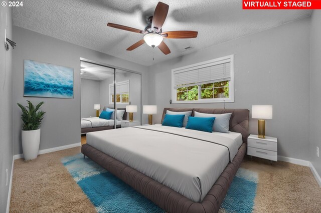 bedroom with ceiling fan, carpet floors, a textured ceiling, and a closet