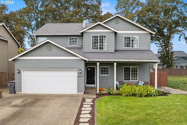 view of front facade featuring a porch, a garage, and a front lawn