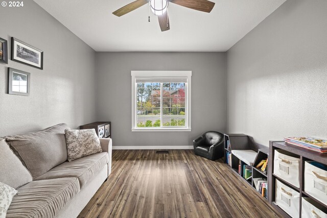 sitting room featuring ceiling fan and dark wood-type flooring