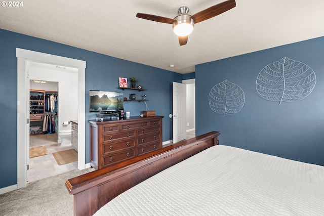 bedroom with light colored carpet, ensuite bath, and ceiling fan