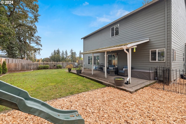 back of property with a patio area, a playground, and a yard