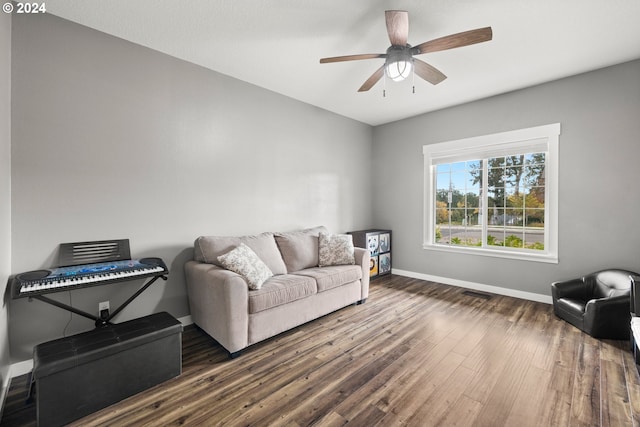 living room with ceiling fan and dark wood-type flooring