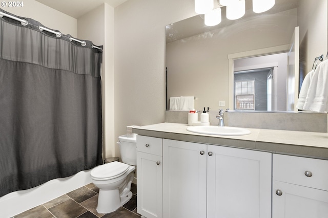 full bathroom with tile patterned floors, shower / bath combo with shower curtain, vanity, and toilet