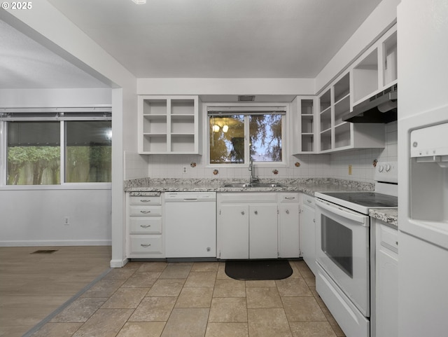 kitchen featuring white appliances, ventilation hood, sink, light stone countertops, and white cabinetry