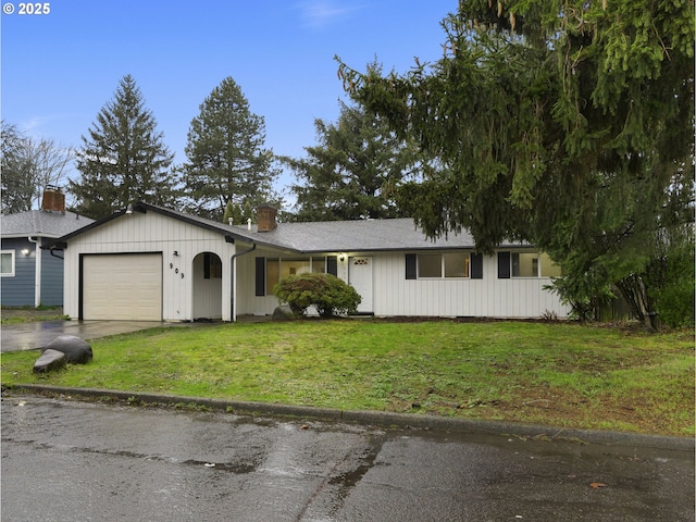 ranch-style house featuring a garage and a front lawn