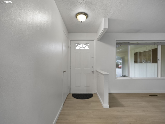 entrance foyer featuring light hardwood / wood-style flooring and a textured ceiling