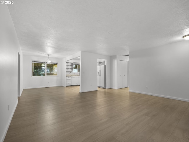 unfurnished living room featuring wood-type flooring and a textured ceiling