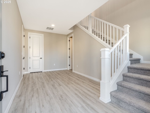 stairway with hardwood / wood-style floors