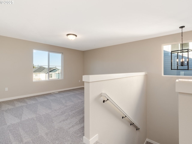 staircase featuring carpet flooring and a notable chandelier