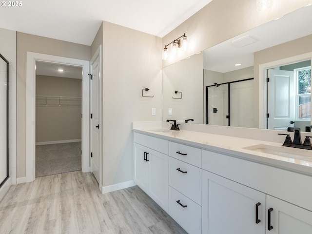 bathroom featuring vanity, wood-type flooring, and a shower with shower door