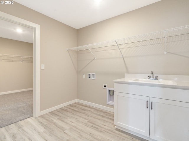 washroom with electric dryer hookup, cabinets, sink, hookup for a washing machine, and light hardwood / wood-style flooring