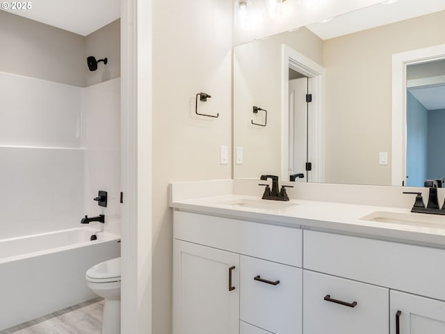 full bathroom with wood-type flooring, vanity, toilet, and shower / washtub combination