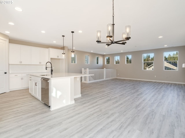 kitchen featuring a center island with sink, light hardwood / wood-style flooring, stainless steel dishwasher, and sink