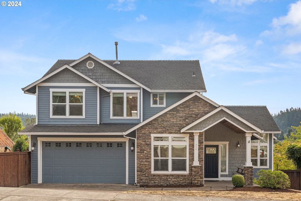 craftsman house with an attached garage, driveway, fence, and a shingled roof