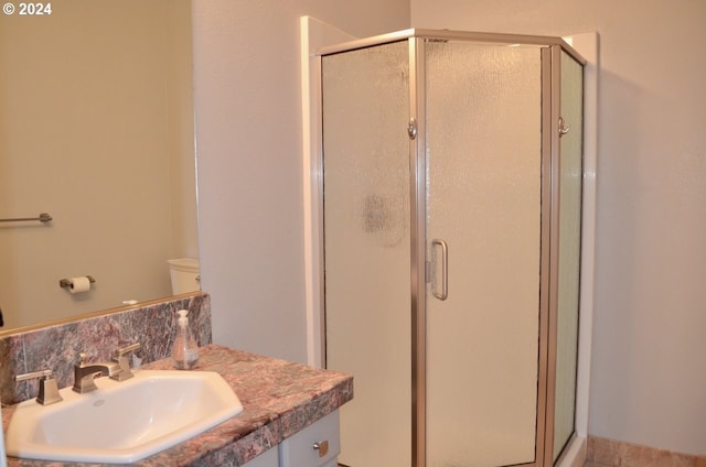 bathroom featuring toilet, vanity, and walk in shower