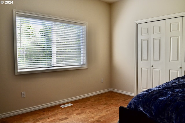 bedroom with light hardwood / wood-style flooring and a closet