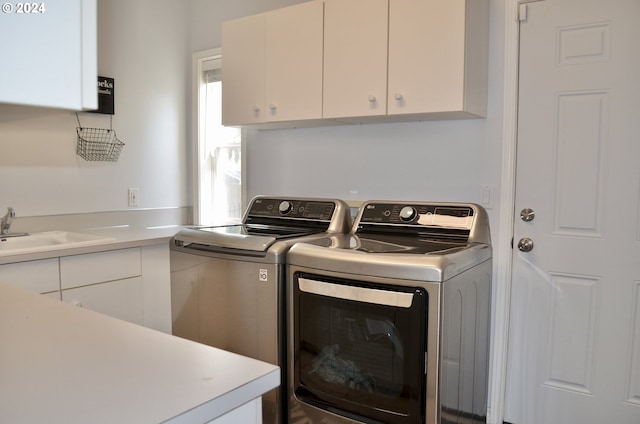 laundry area featuring sink, cabinets, and independent washer and dryer