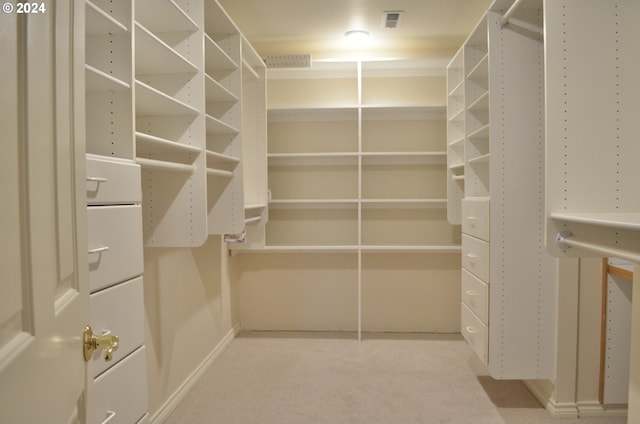 walk in closet featuring light carpet