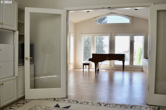 miscellaneous room featuring light hardwood / wood-style flooring and vaulted ceiling