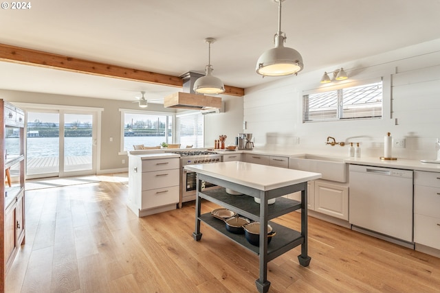 kitchen featuring appliances with stainless steel finishes, light hardwood / wood-style floors, white cabinetry, and pendant lighting