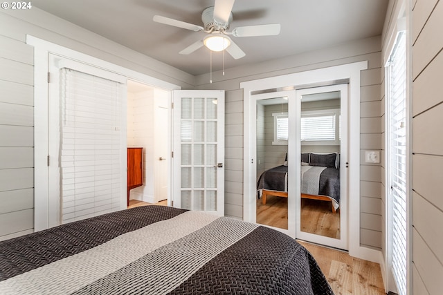 bedroom with french doors, light hardwood / wood-style flooring, and ceiling fan