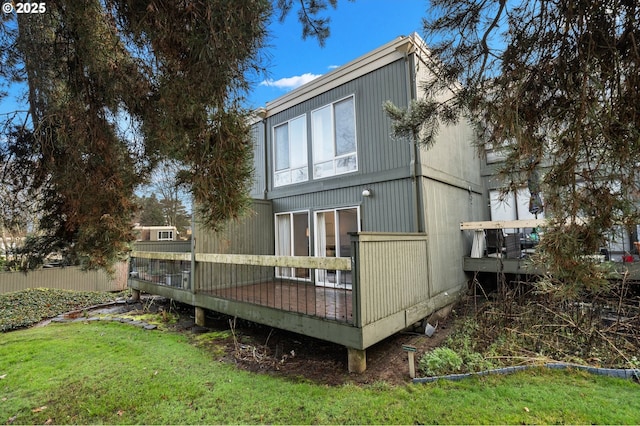 back of house featuring a wooden deck and a lawn