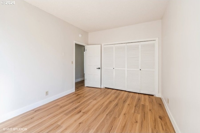 unfurnished bedroom with a closet and light hardwood / wood-style floors