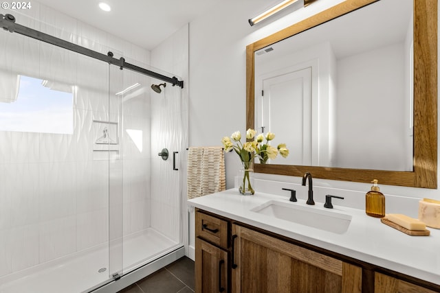 bathroom with tile flooring, an enclosed shower, and vanity