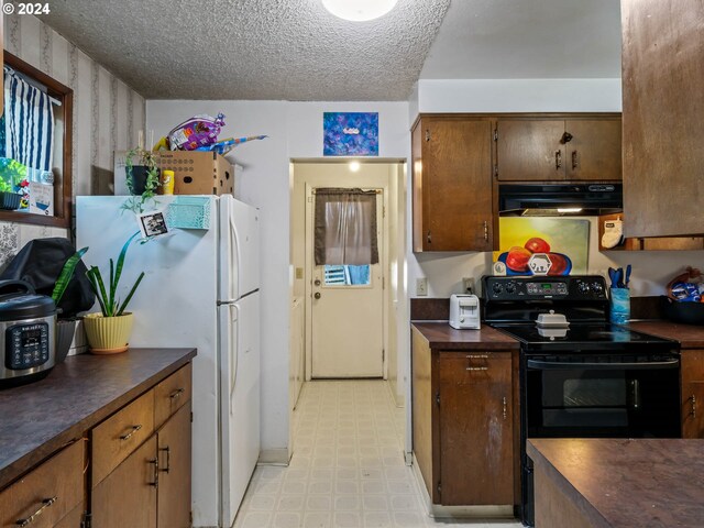 kitchen featuring black / electric stove, a textured ceiling, and white refrigerator