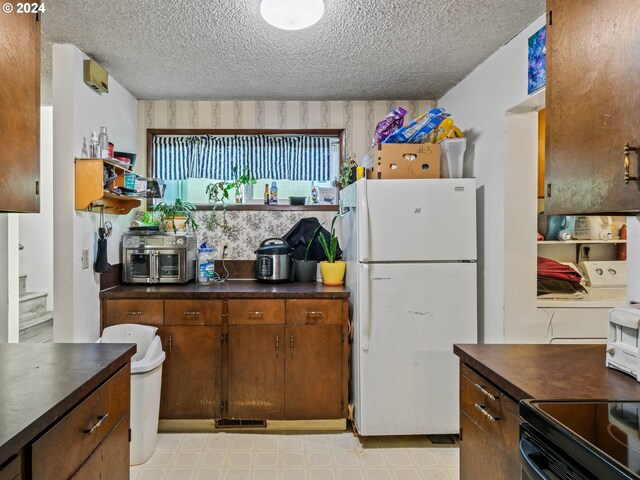 kitchen featuring a textured ceiling and white refrigerator