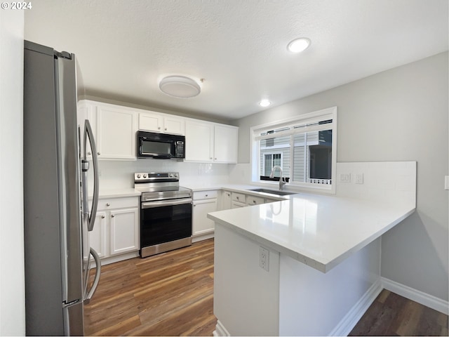 kitchen featuring stainless steel appliances, sink, hardwood / wood-style flooring, and kitchen peninsula