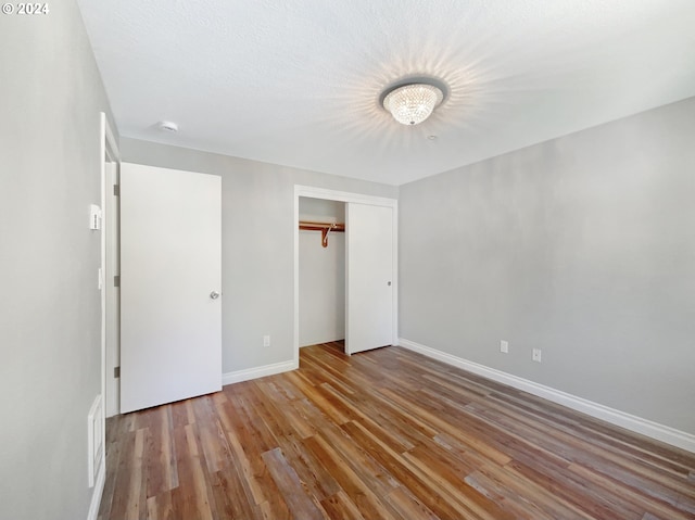 unfurnished bedroom with a closet and hardwood / wood-style floors