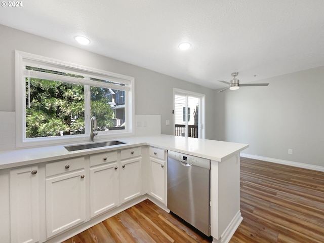 kitchen featuring white cabinetry, hardwood / wood-style flooring, kitchen peninsula, sink, and dishwasher