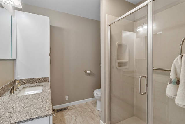 bathroom featuring vanity, tile patterned flooring, a shower with door, and toilet