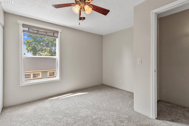 spare room featuring ceiling fan, carpet floors, and a textured ceiling