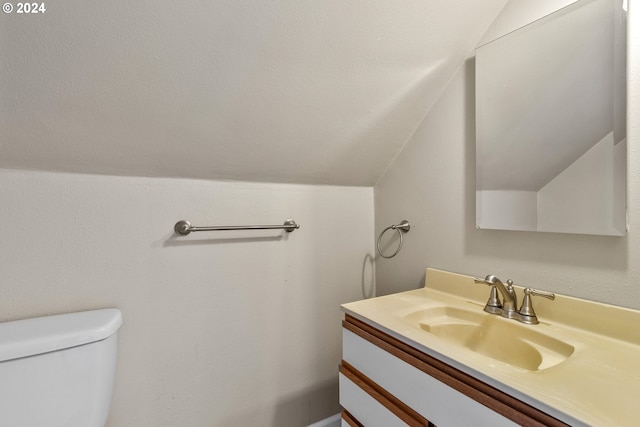 bathroom with vanity, vaulted ceiling, and toilet