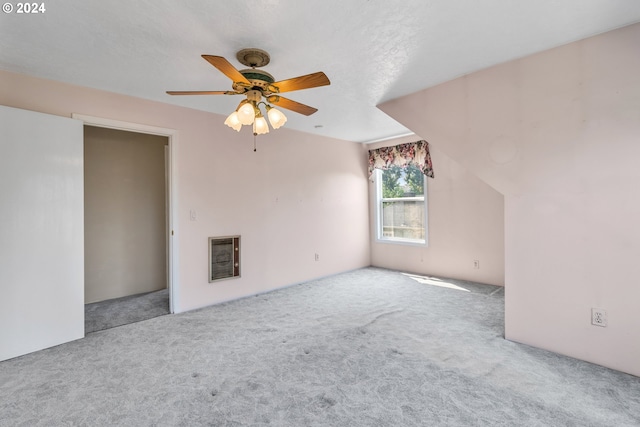 interior space featuring ceiling fan, light colored carpet, and heating unit