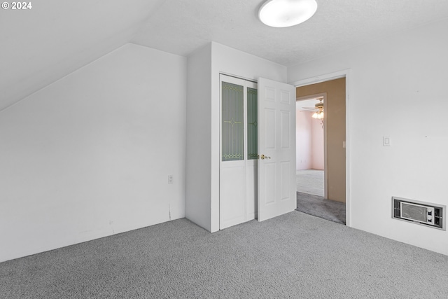 bonus room with lofted ceiling, carpet flooring, and a textured ceiling