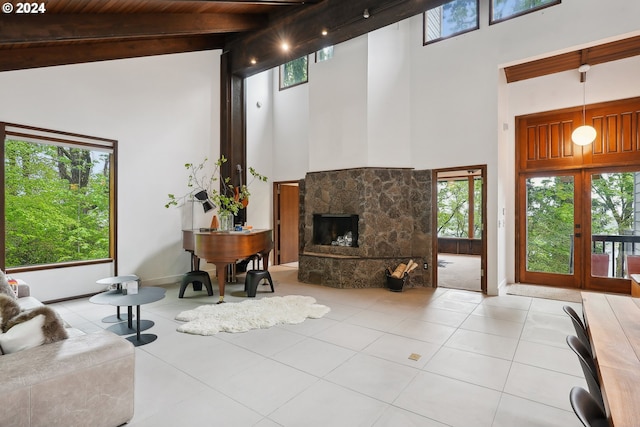 living area featuring beamed ceiling, a stone fireplace, high vaulted ceiling, and light tile patterned floors