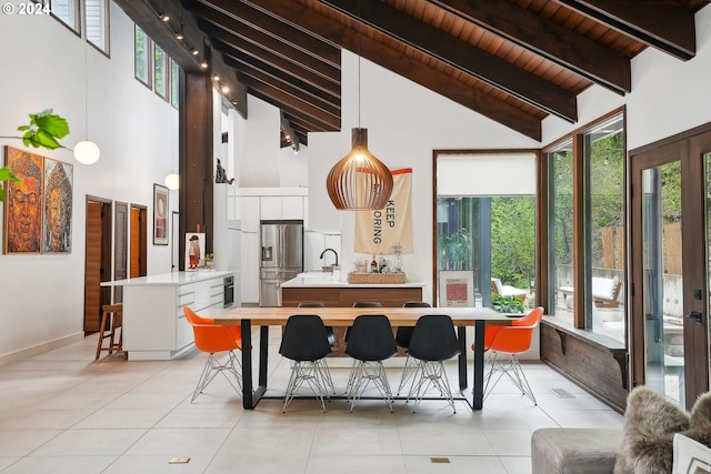 kitchen featuring plenty of natural light, light countertops, a peninsula, and stainless steel fridge with ice dispenser