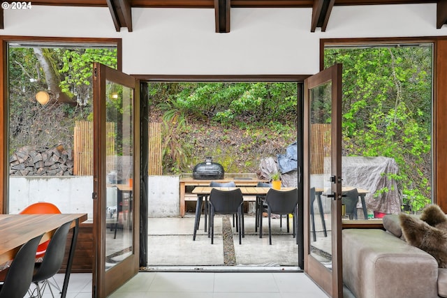 doorway to outside with beam ceiling, tile patterned flooring, and french doors