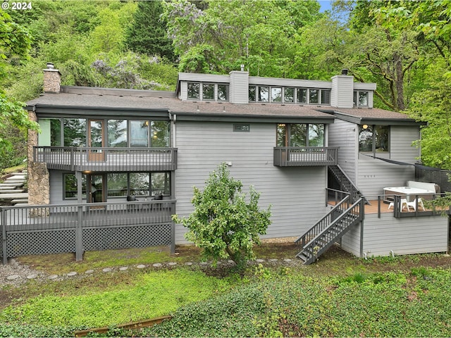 rear view of house featuring a balcony and a deck