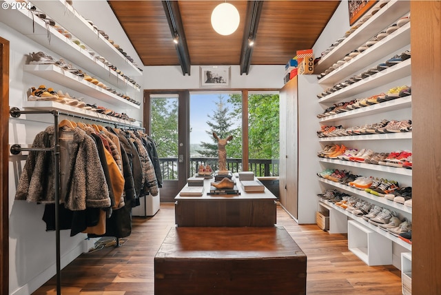 walk in closet with hardwood / wood-style floors and lofted ceiling with beams