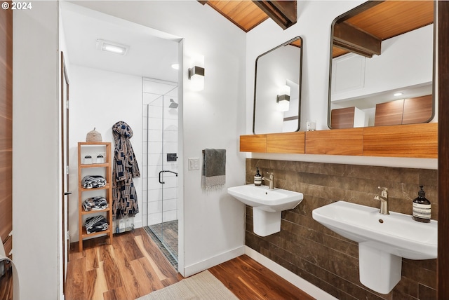 full bathroom with a shower stall, beam ceiling, and wood finished floors